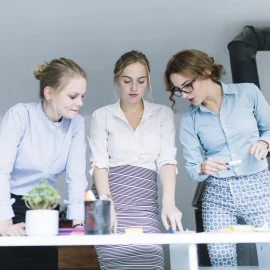Colege discută un proiect la masa de lucru
