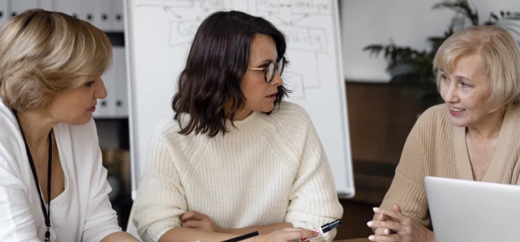Discuție între colege în jurul unei mese